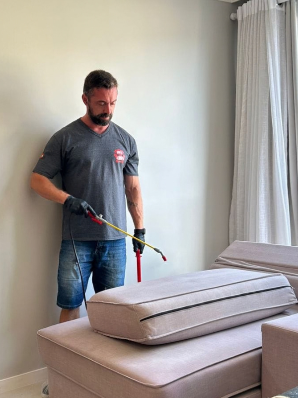 Técnico da Sofá Carro Limpo Express aplicando produto profissional para higienização e limpeza de sofá a domicílio em Balneário Camboriú